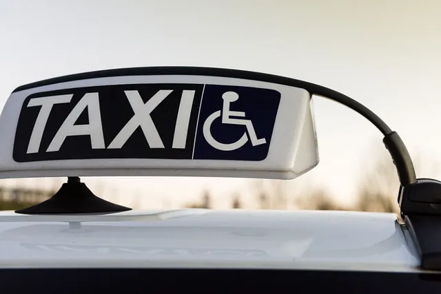 Ein weißes Schild eines Taxis, welches Taxi Krankenfahrten in Bremen speziell für mobil eingeschränkte Menschen durchführt.